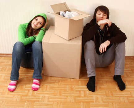 Packing boxes and wrapping fragile household items for a move in Tooting