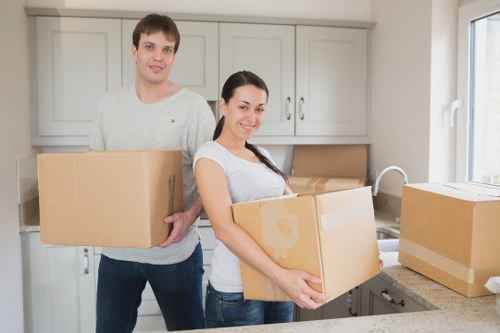 Local movers carrying items through a communal stairwell in Tooting